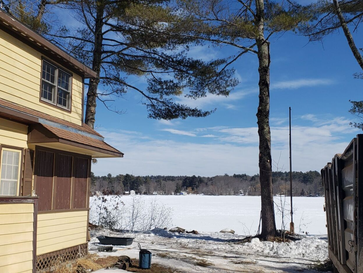 A house with a lot of snow on the ground in front of it