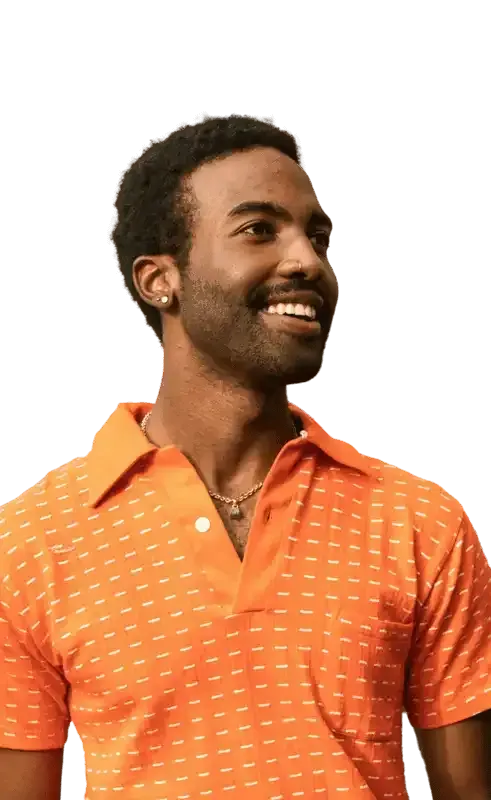 Man in orange polo shirt smiles, looking to the side.