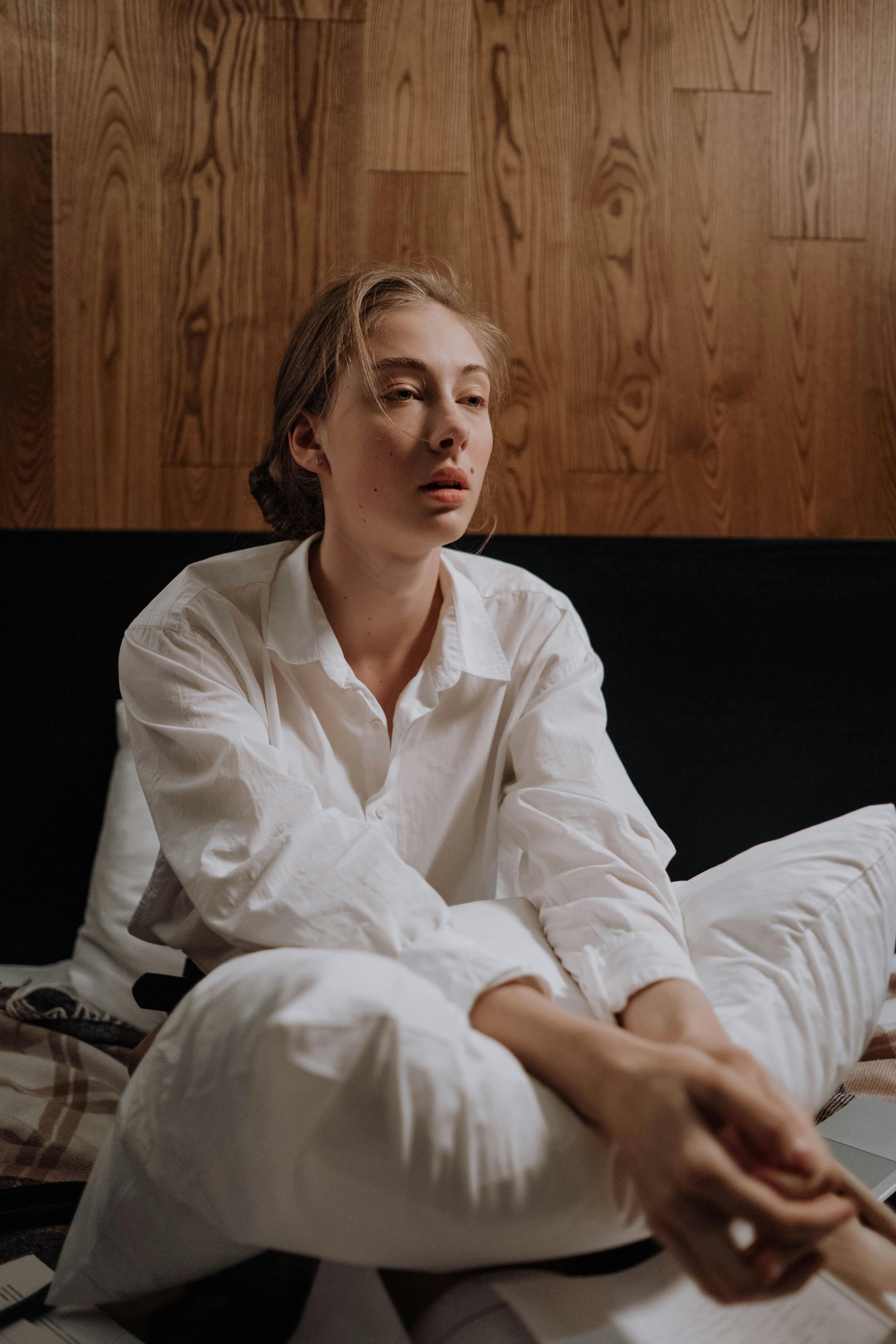 Couple asleep in bed, covered with a white blanket. Warm light and cozy setting.
