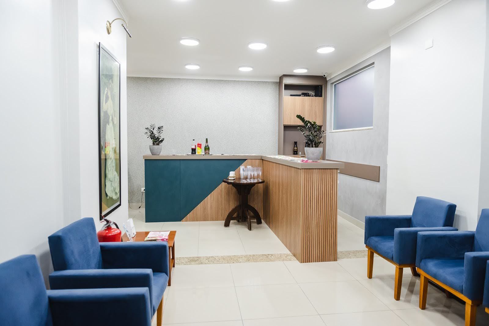 Uma sala de espera com cadeiras azuis e um balcão.
