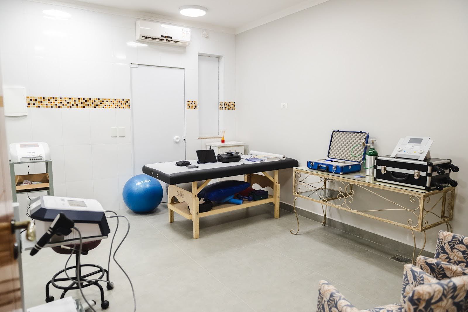 Uma sala com mesa, cadeira e uma bola azul.