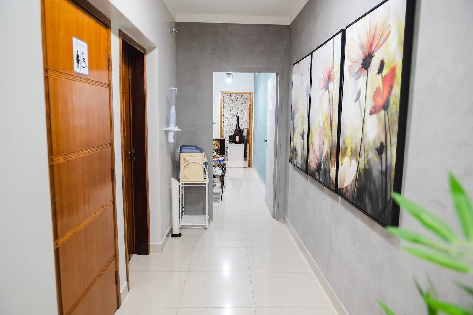 Um longo corredor com muitas portas e pinturas na parede.