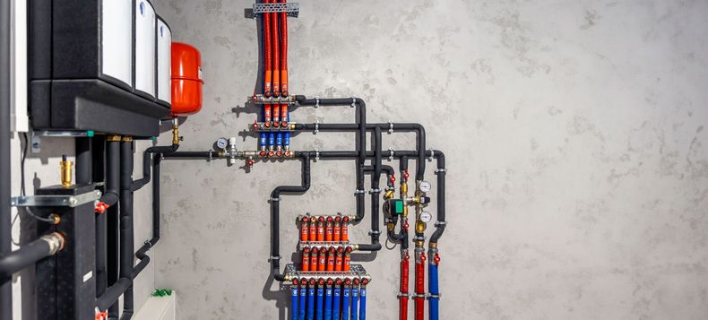 A room with a lot of pipes hanging on the wall.