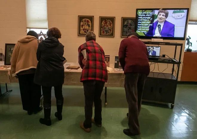 A group of people are looking at a tv screen
