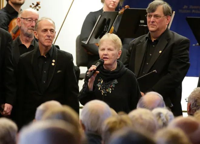 A woman singing into a microphone in front of a crowd