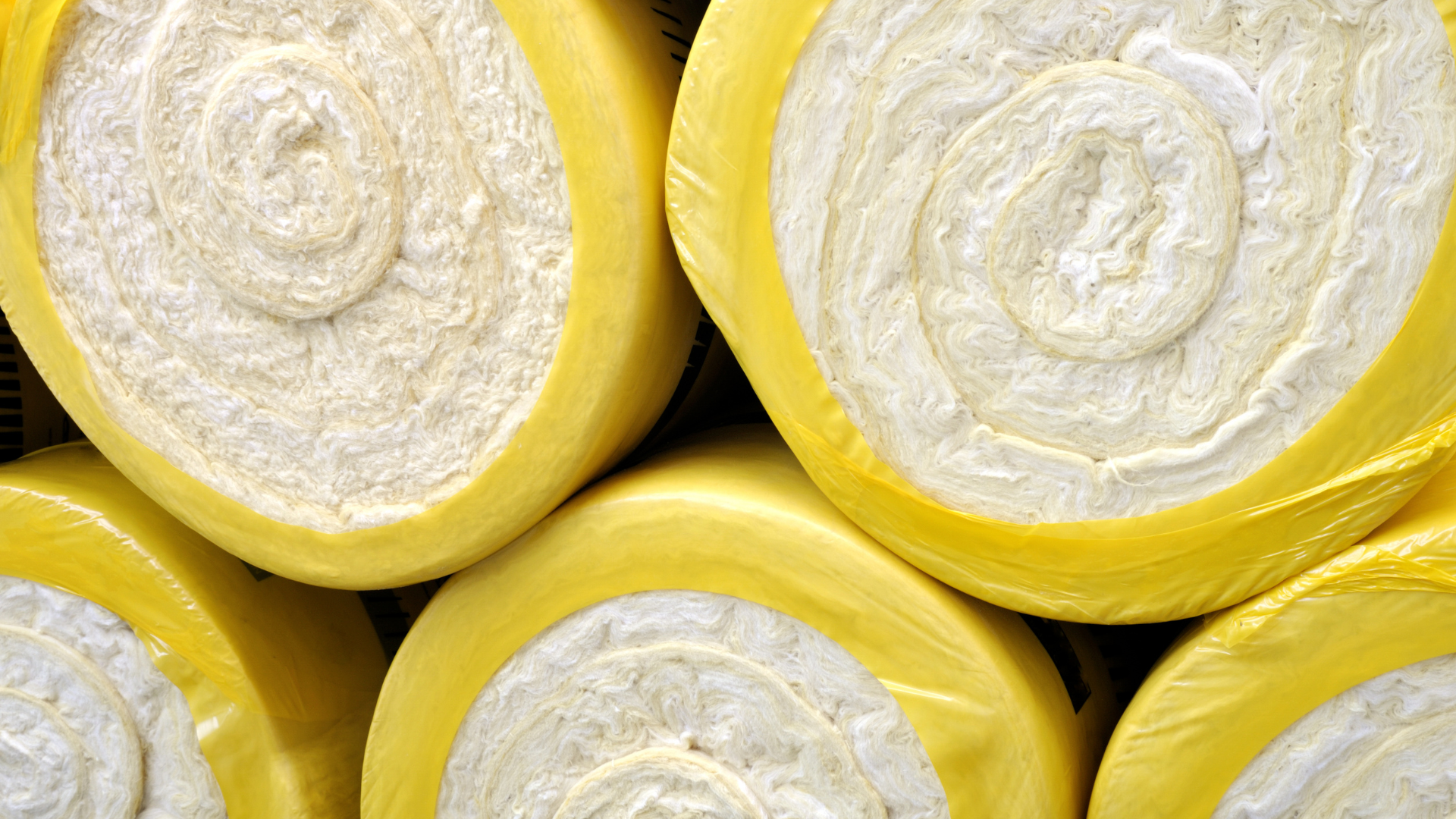 a bunch of yellow rolls of insulation are stacked on top of each other .