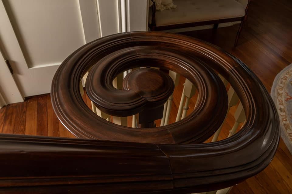 A close up of a wooden spiral staircase in a house.