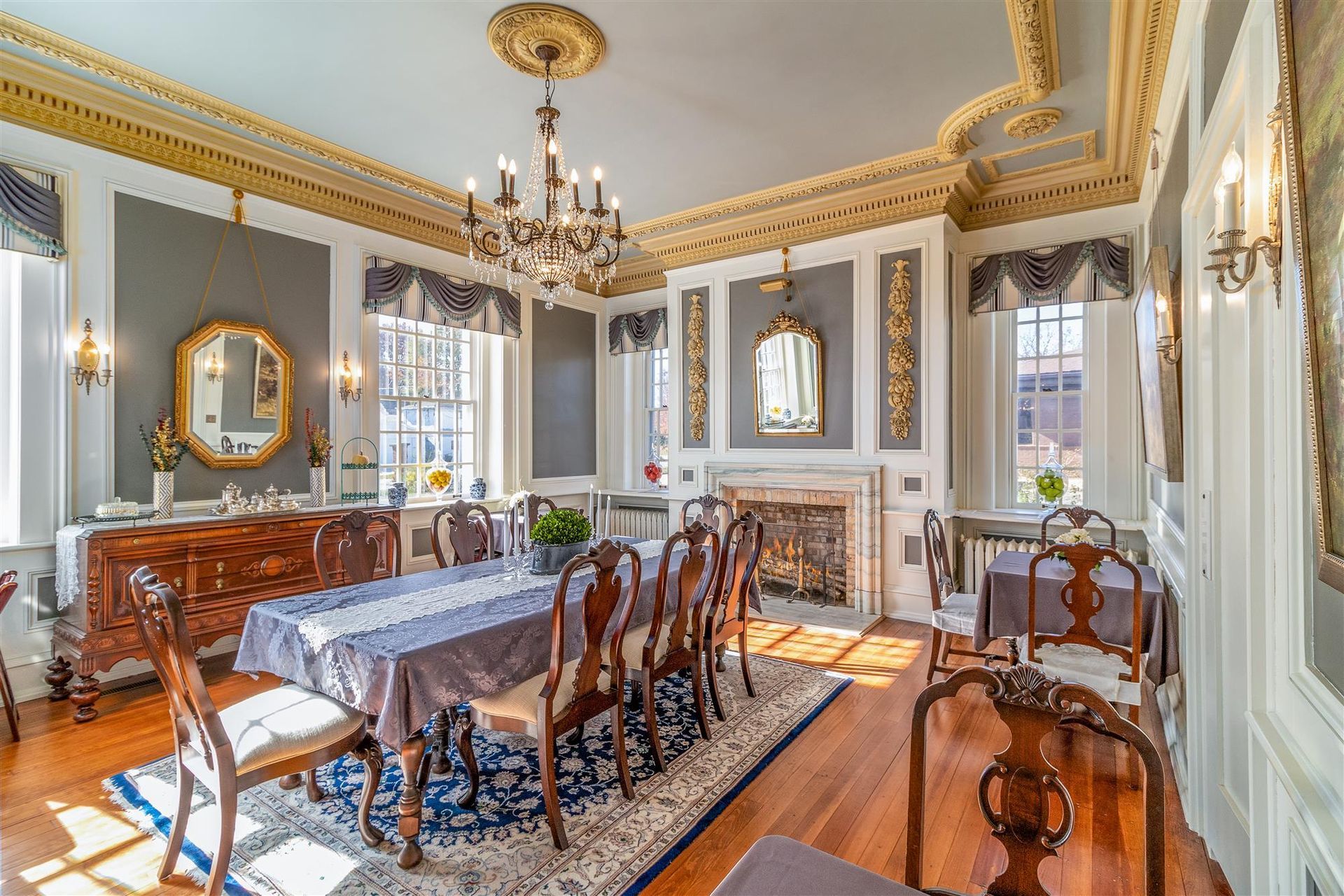 A dining room with a table and chairs and a fireplace.