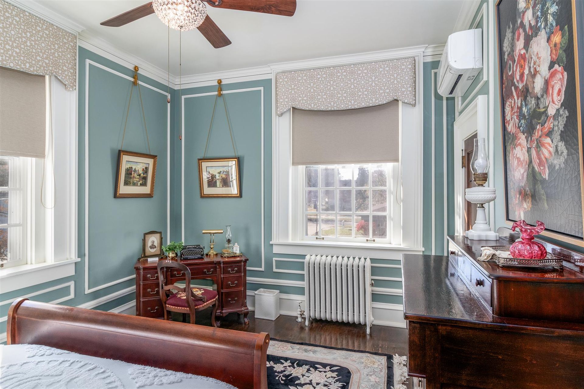 A bedroom with a bed , desk , chair and ceiling fan.