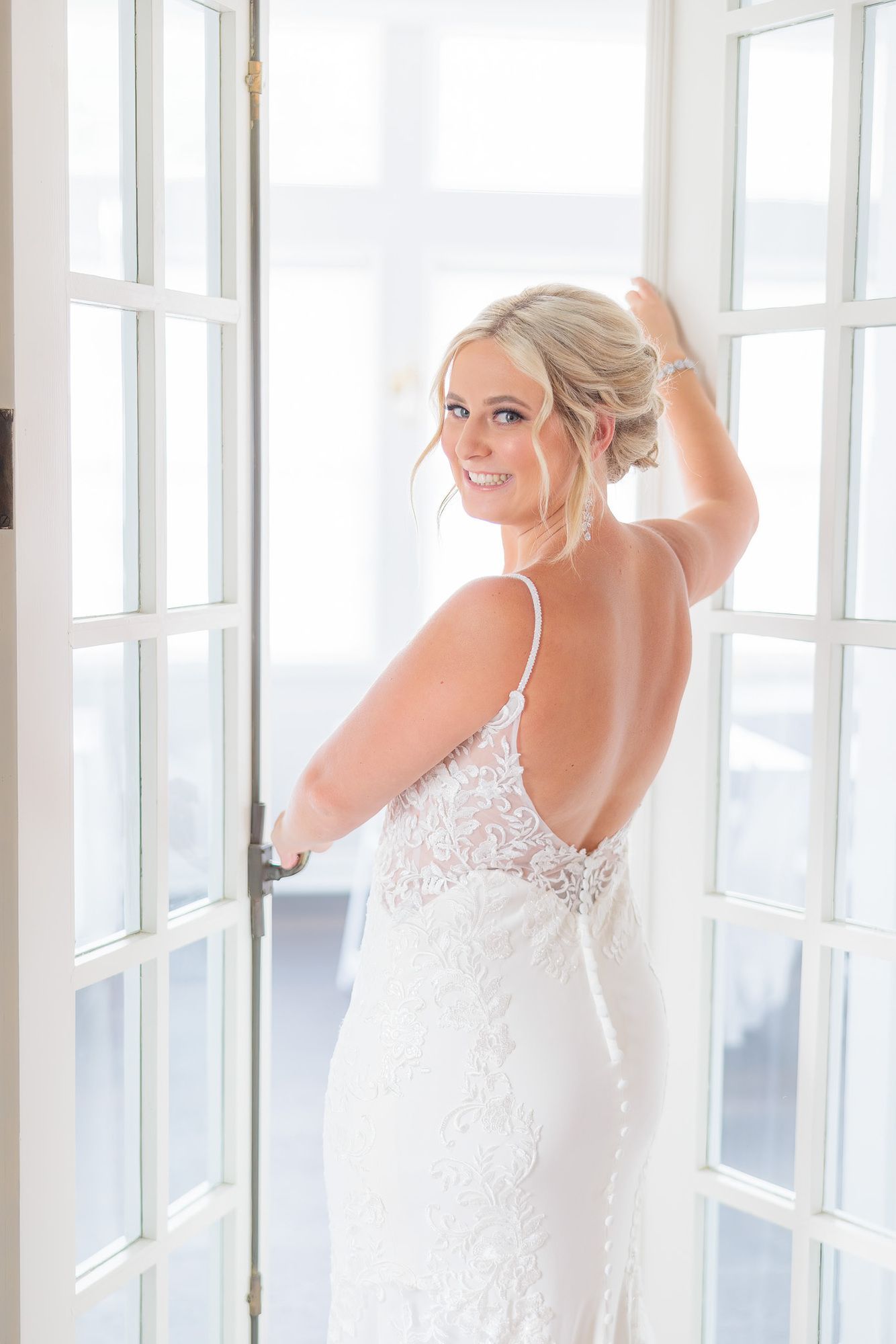 A woman in a wedding dress is standing in front of a door.