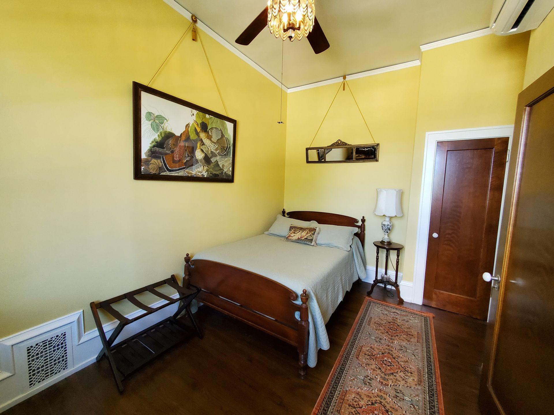 A bedroom with a bed and a ceiling fan