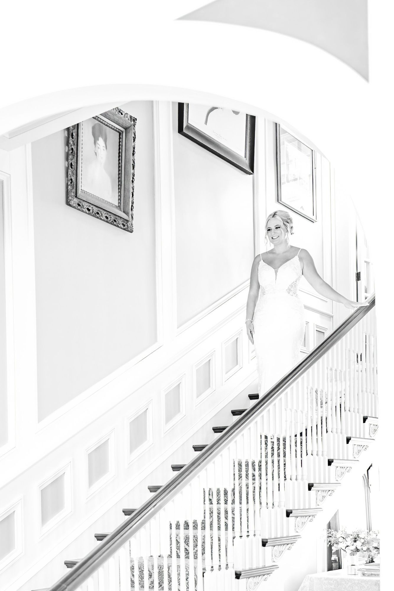 A bride in a wedding dress is standing on a set of stairs.