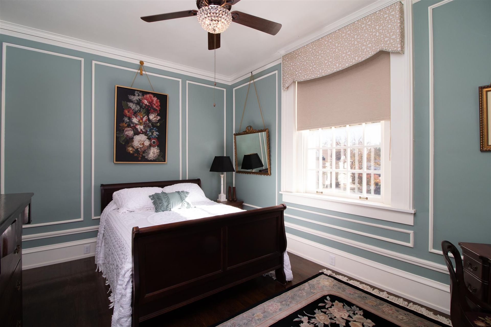 A bedroom with a bed and a ceiling fan