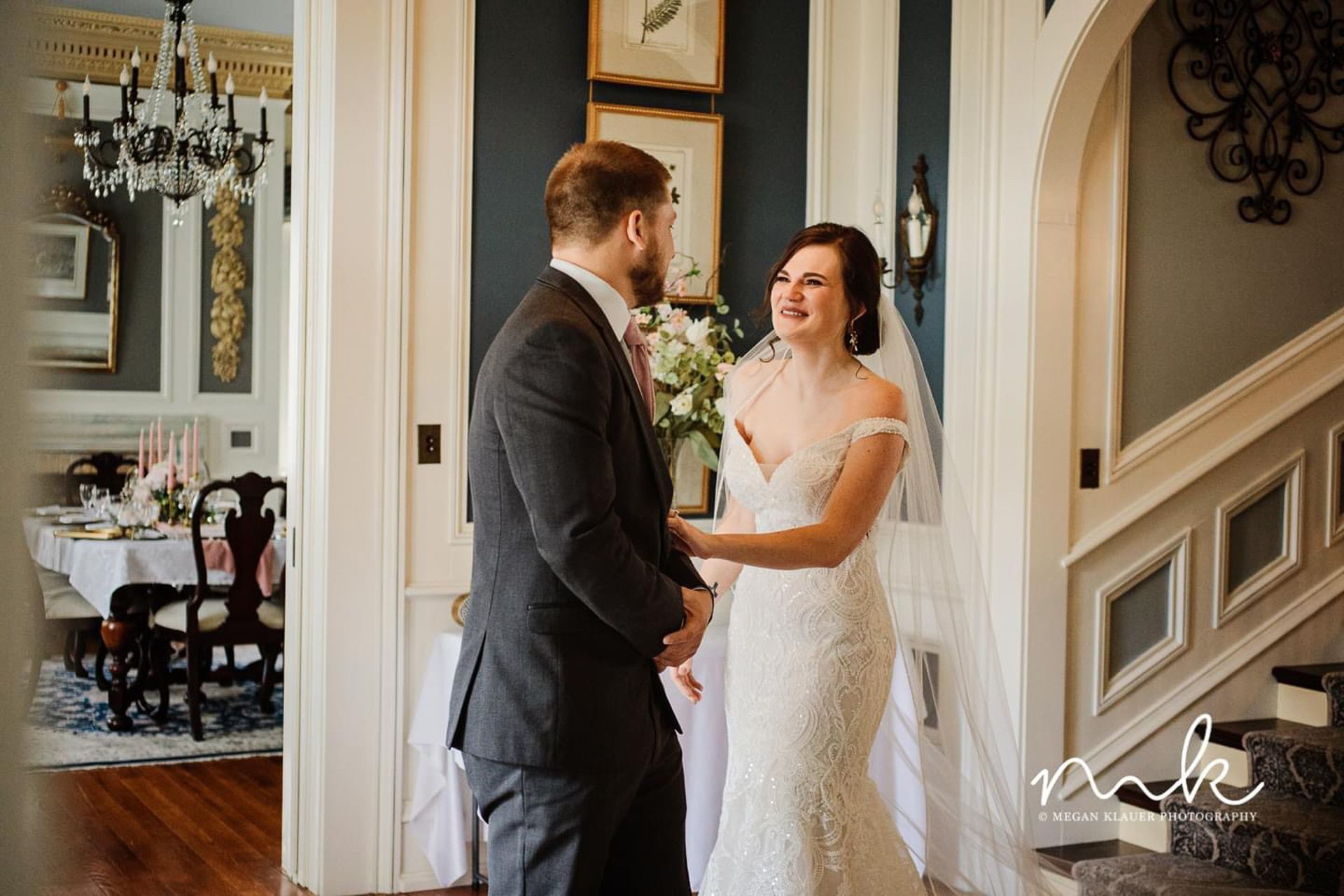 A bride and groom are holding hands in a hallway.