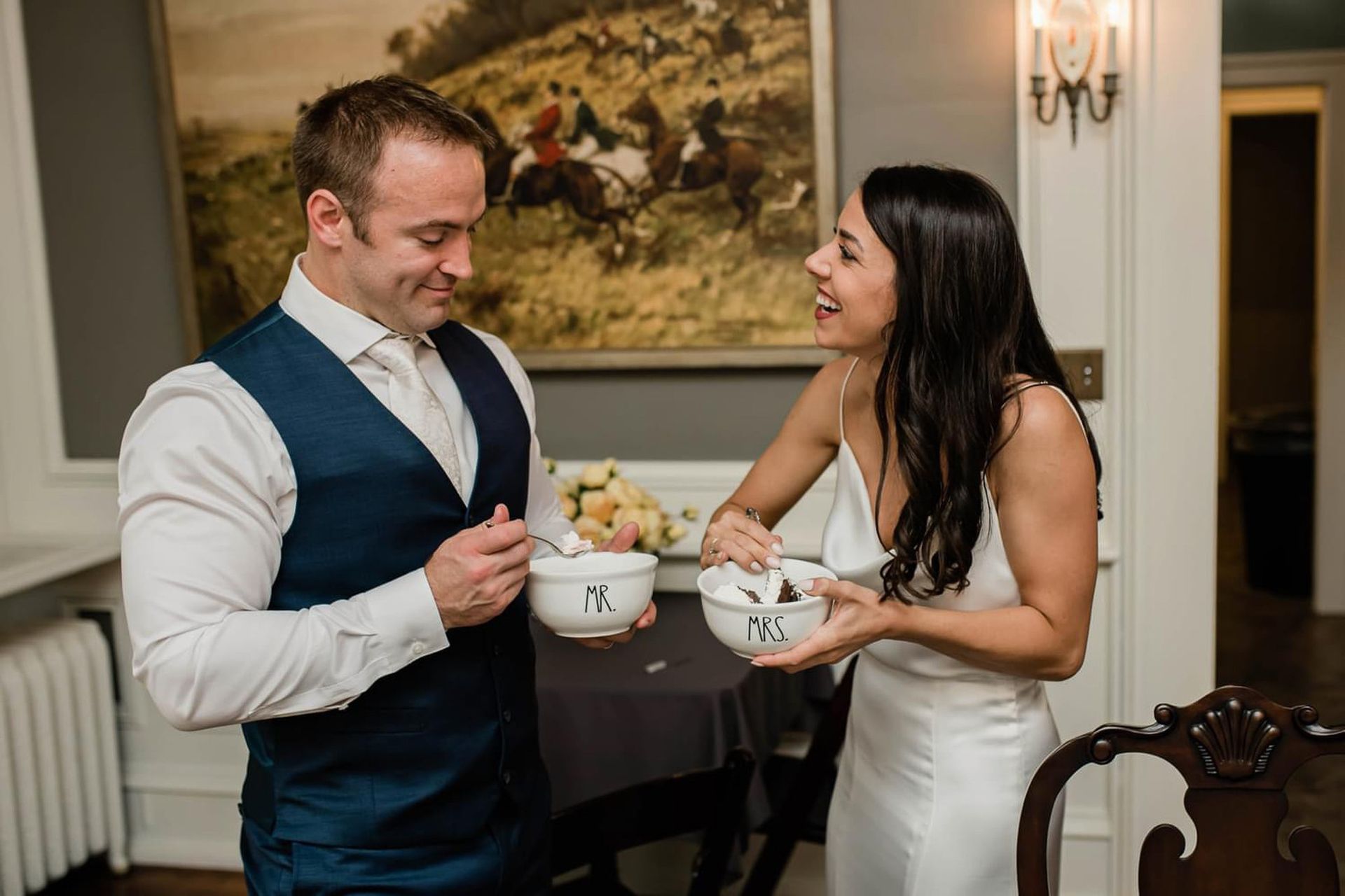 A man and a woman are standing next to each other holding bowls of food.