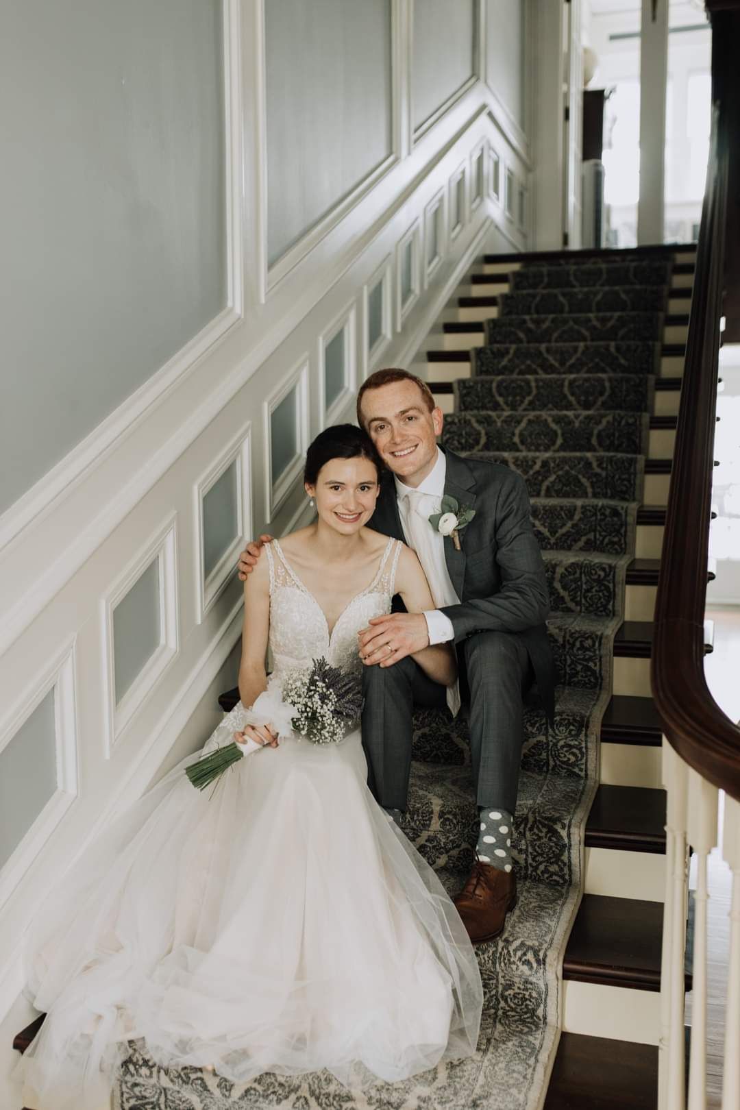 A bride and groom are sitting on a set of stairs.