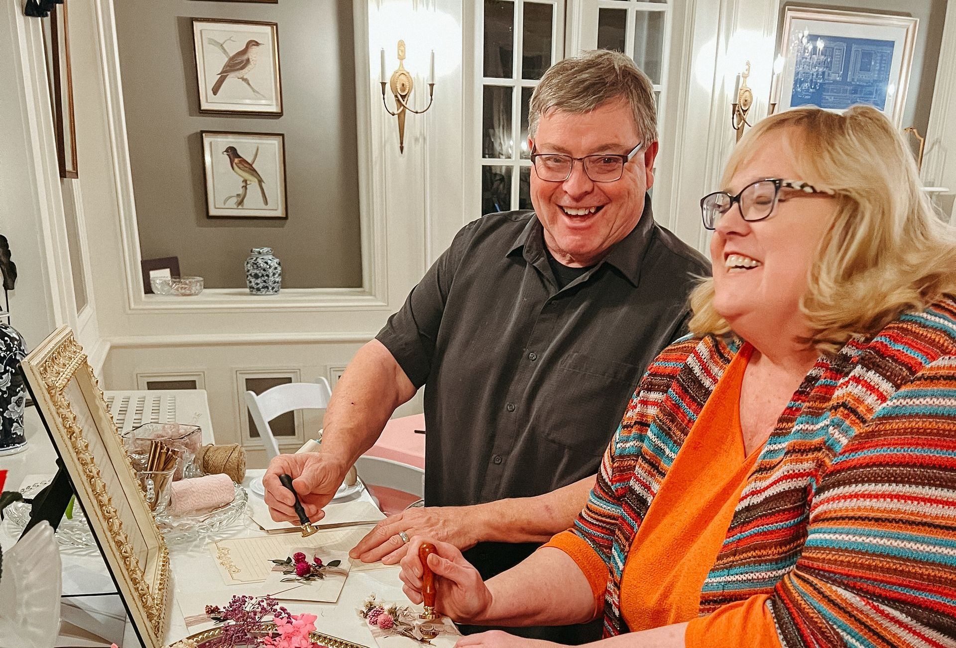 A man and a woman are sitting at a table and smiling.