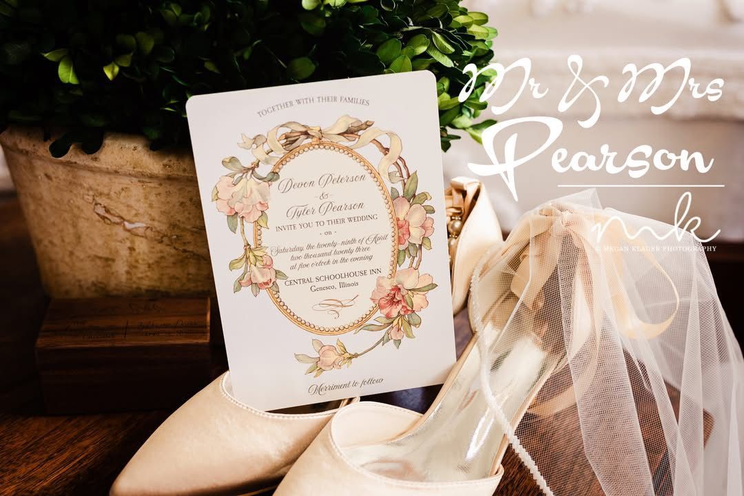 A wedding invitation is sitting next to a pair of shoes and a veil.