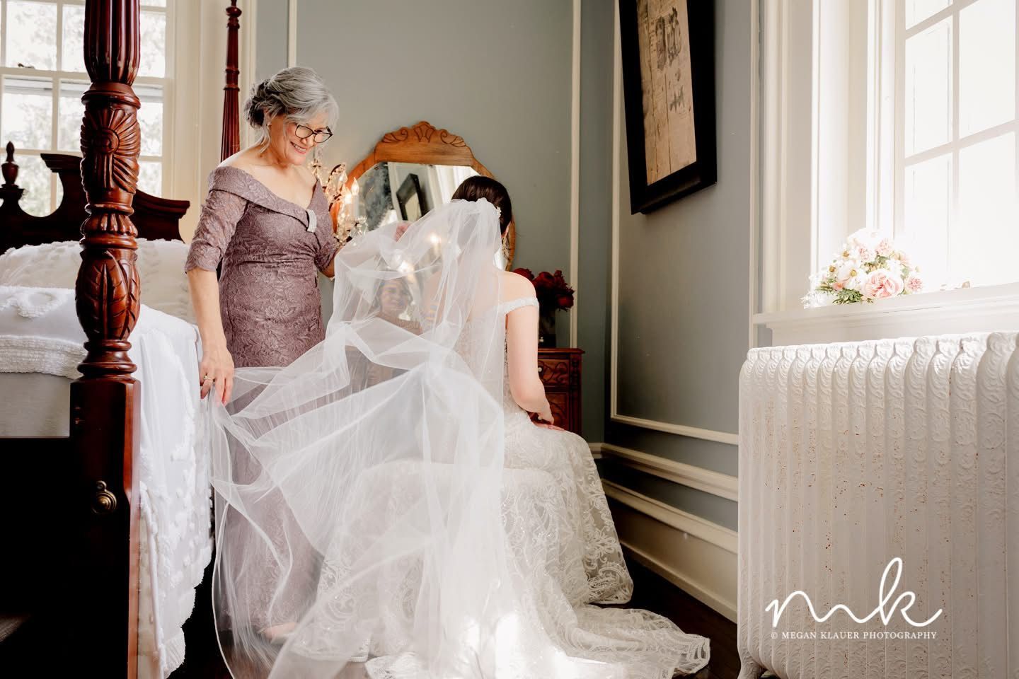 A woman is helping a bride get ready for her wedding.