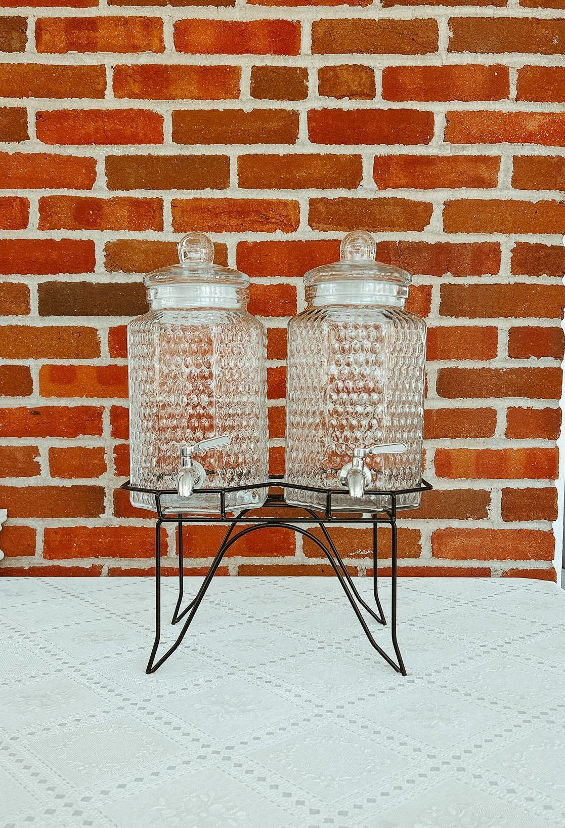 Two glass jars are sitting on a metal stand on a table.