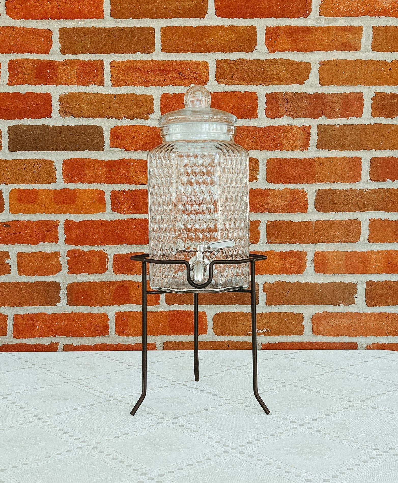 A glass jar is sitting on a metal stand on a table.