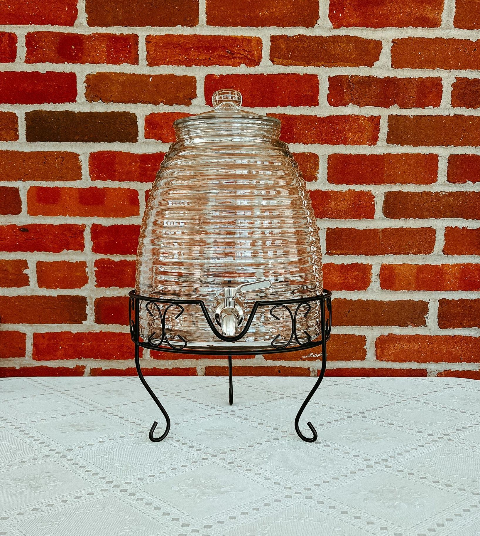 A glass container is sitting on a table next to a window.