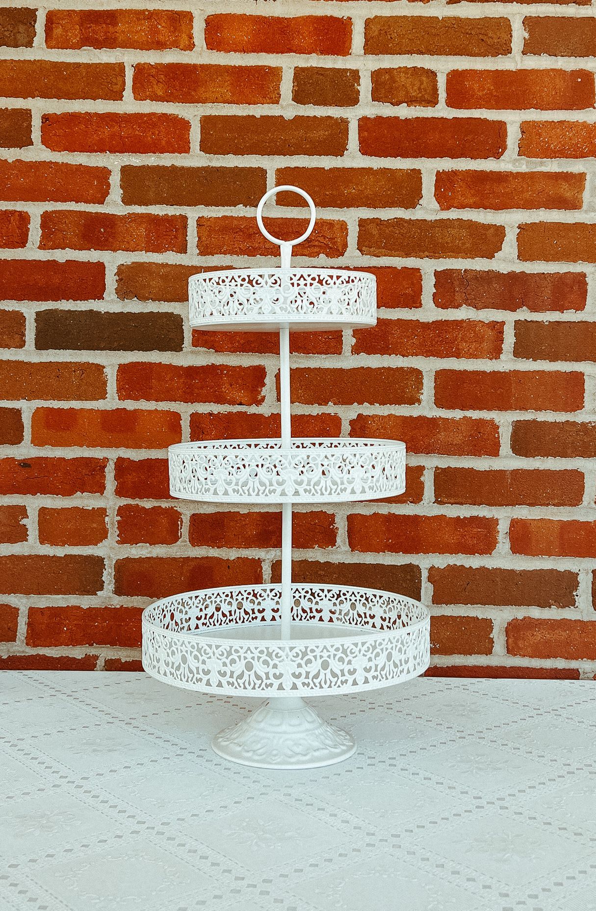 A white cake stand is sitting on a table