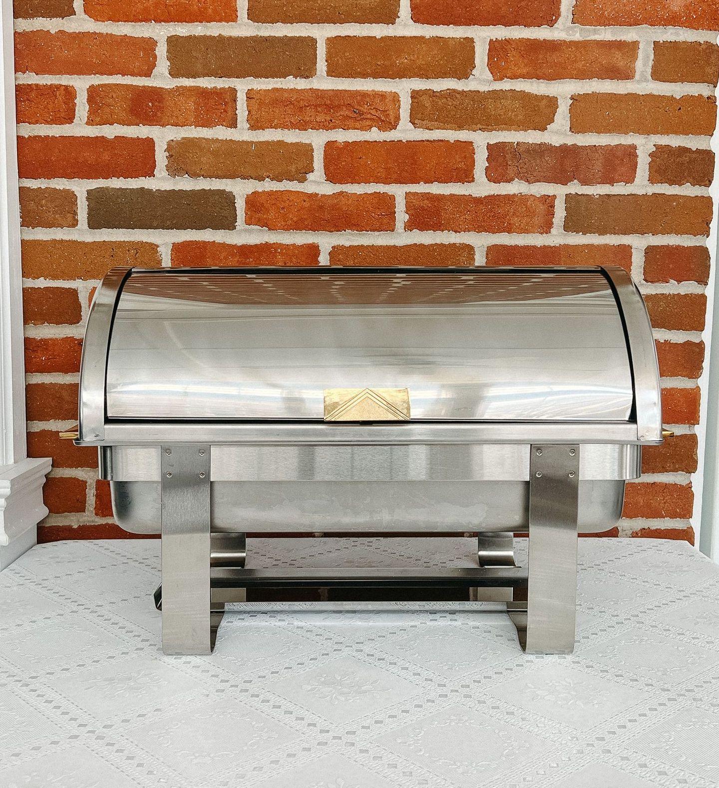 A stainless steel chafing dish is sitting on a table.