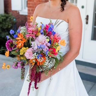 A woman in a white dress is holding a bouquet of flowers