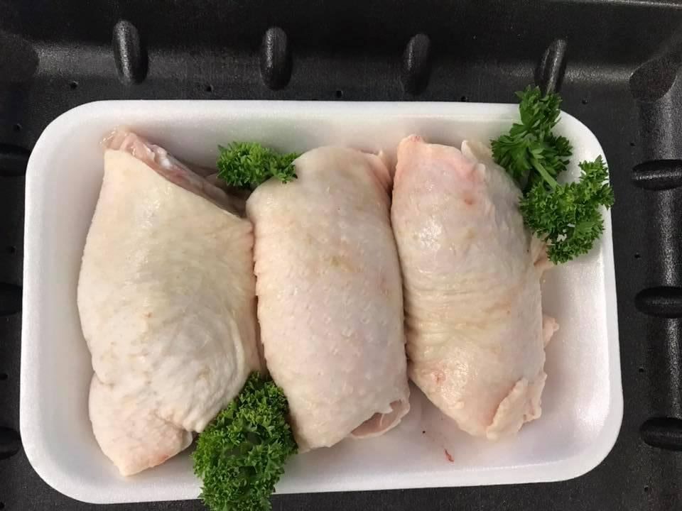 Three Chicken Thighs Are in A Styrofoam Tray with Parsley — Holiday Coast Meat & Smallgoods in Grafton, NSW