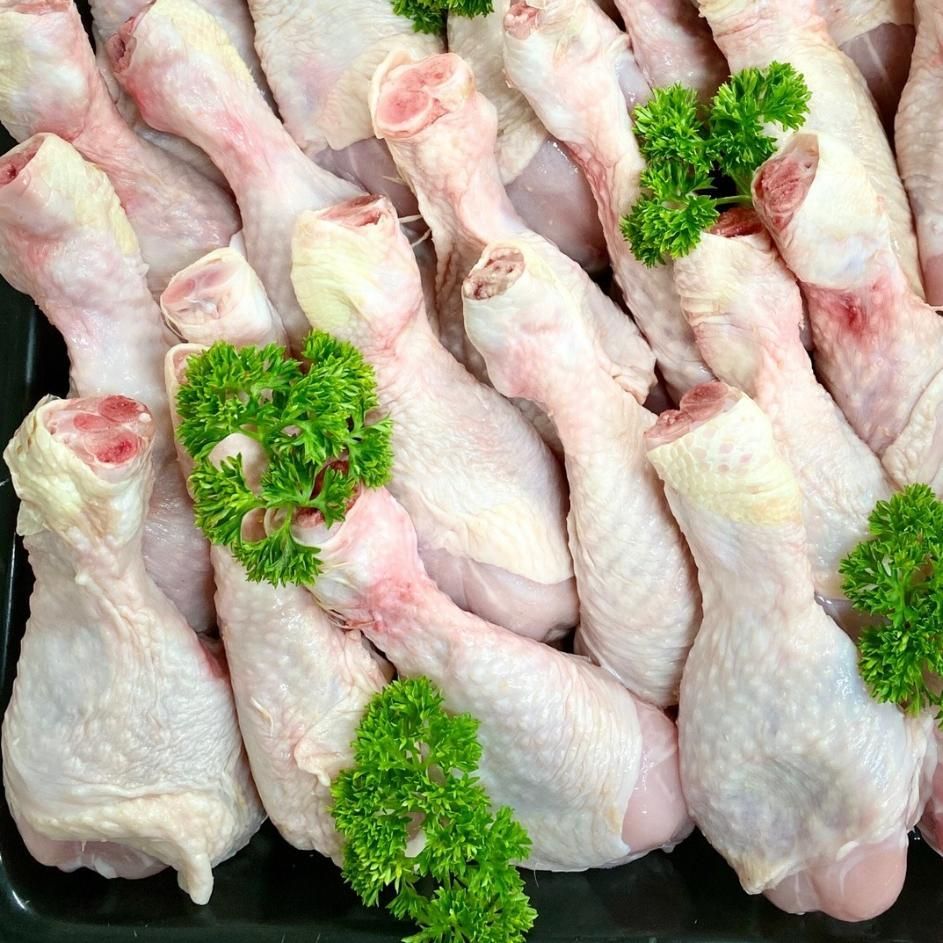 A Pile of Raw Chicken Legs with Parsley on Top — Holiday Coast Meat & Smallgoods in Glenn Innes, NSW