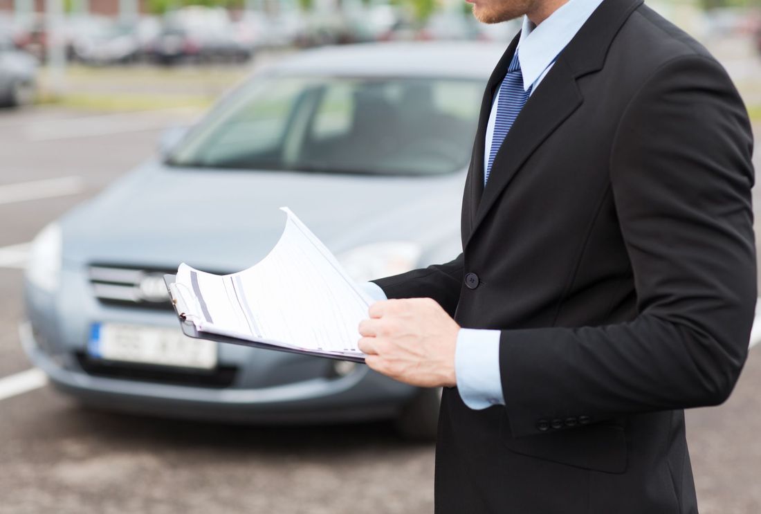 Uomo d'affari consulta un contratto di noleggio auto