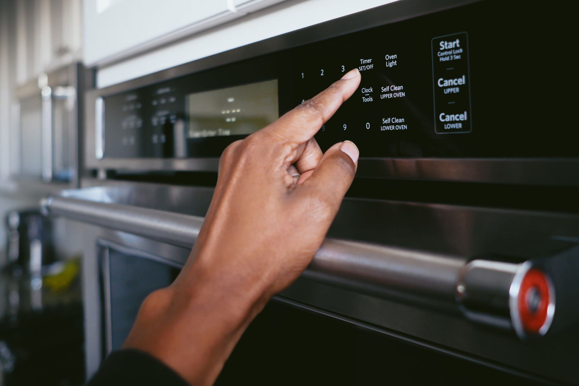 Woman pressing timer on oven - Roanoke, VA - Appliance Repair Service