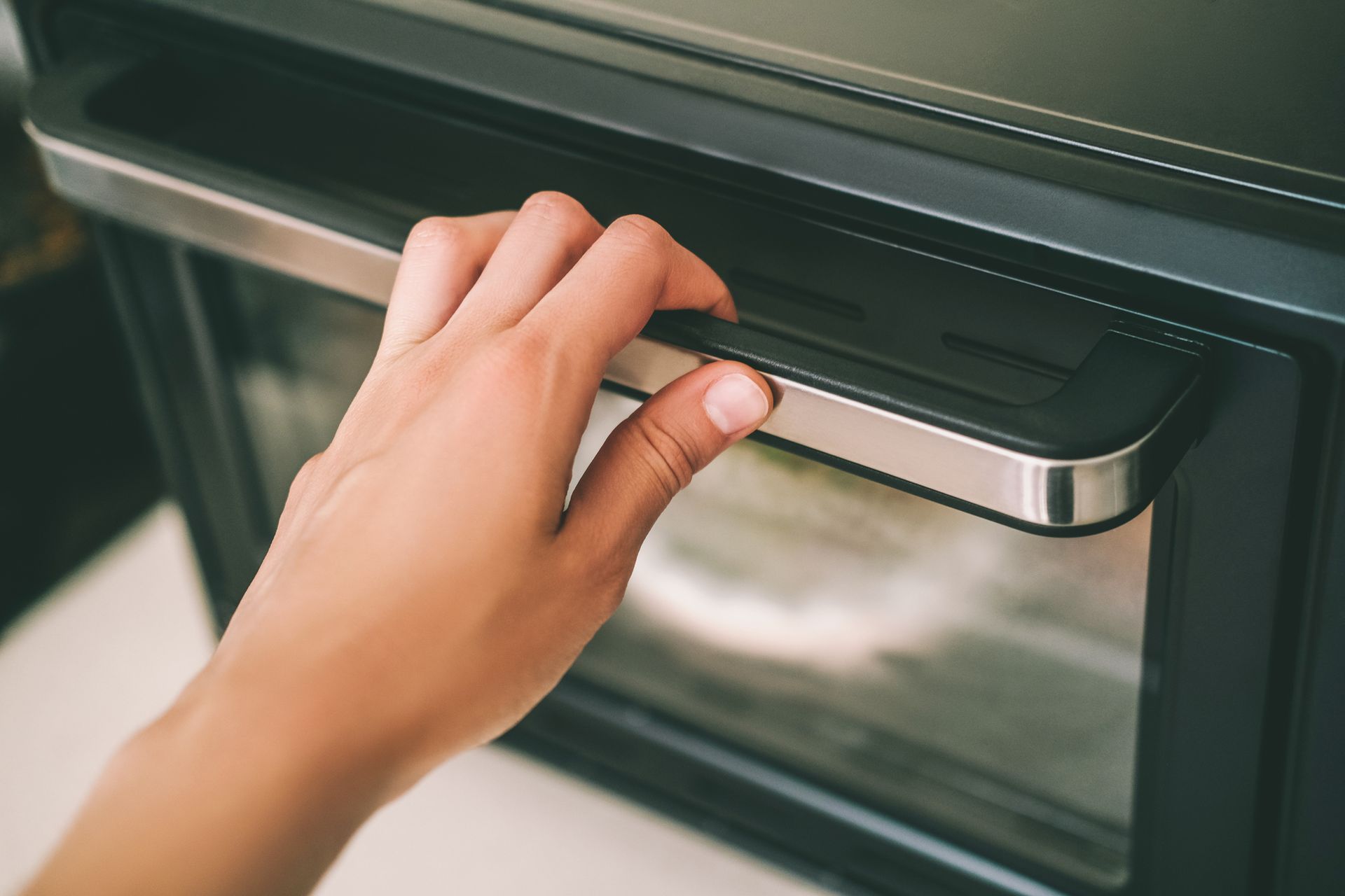 Hand holding oven door - Roanoke, VA - Appliance Repair Service