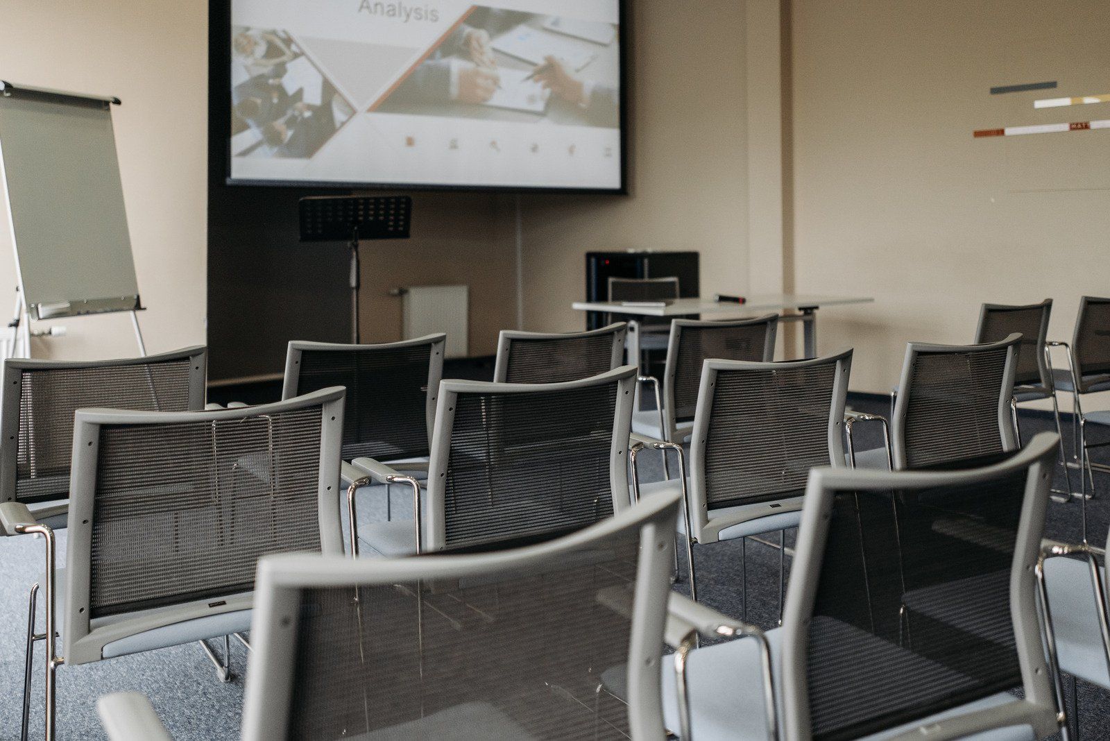 Empty conference room with chairs facing a projector screen displaying a presentation.