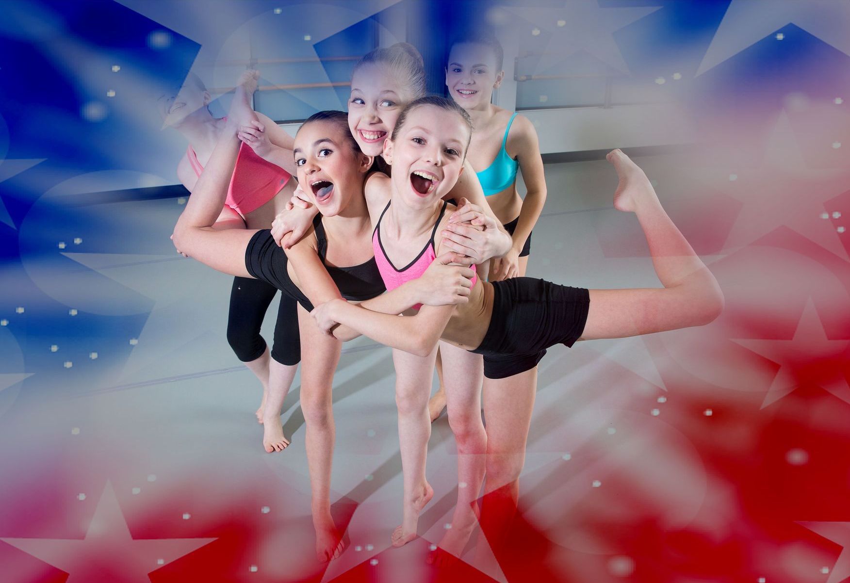 A group of young girls are posing for a picture in a dance studio.