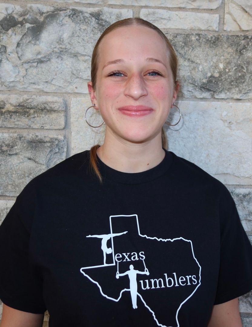 A man wearing a straw hat is smiling and looking up.