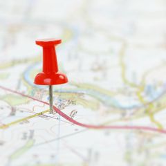 A red pin is sitting on top of a map.