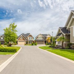 A row of houses are lined up on a residential street.