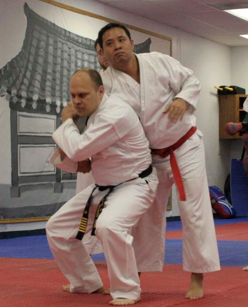 Two men are practicing martial arts in a gym