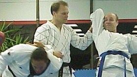 A group of men are practicing martial arts in a gym.