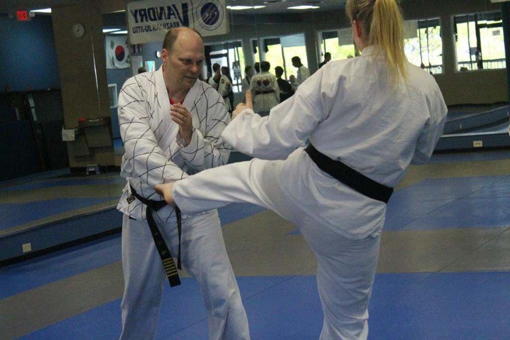 A man and a woman are practicing karate in a gym