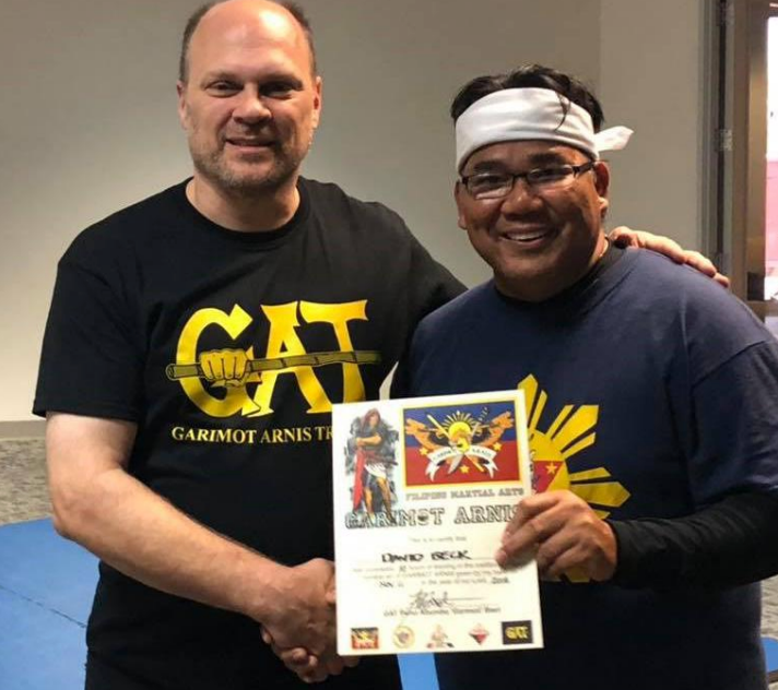 A man wearing a cat shirt shakes hands with another man