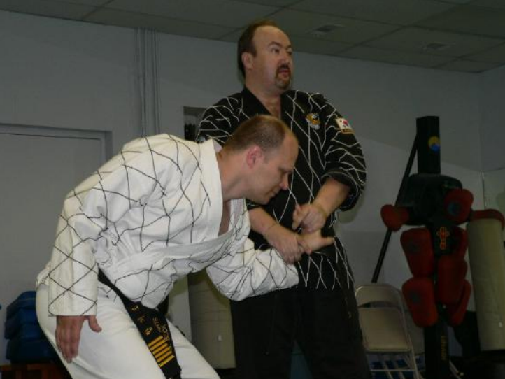 Two men are practicing martial arts in a gym