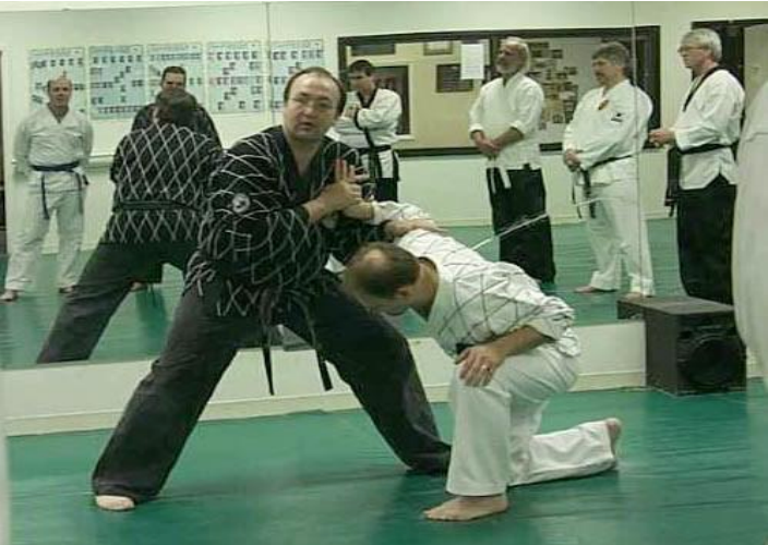 A group of men are practicing martial arts in front of a mirror.