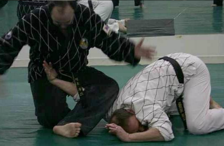 Two men are practicing martial arts on a mat.