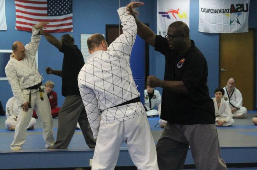 A group of men are practicing martial arts in front of an american flag