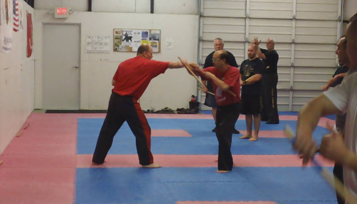 A group of people are practicing martial arts in a gym