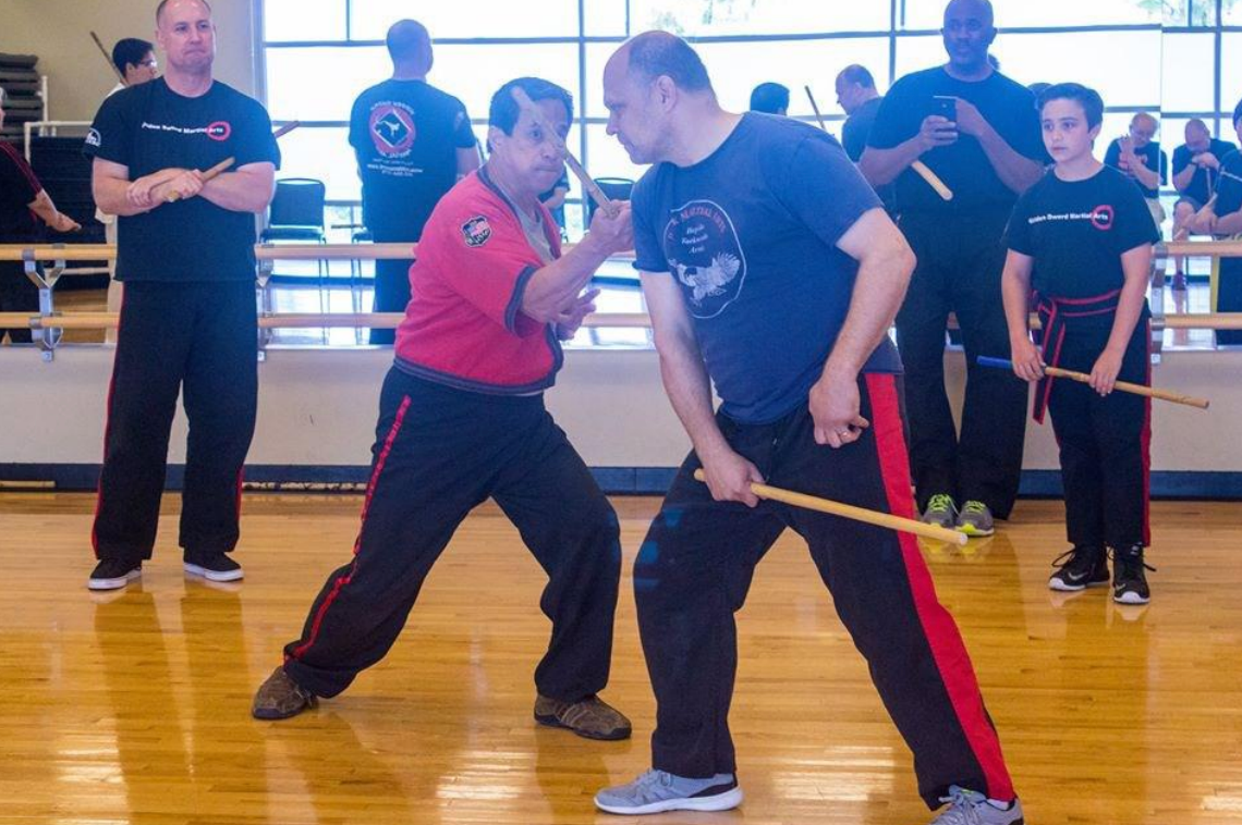 A group of men are practicing martial arts in a gym