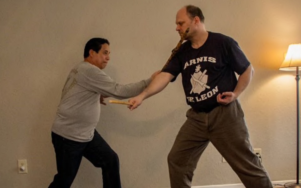 A man in an annis leon shirt is holding another man 's hand